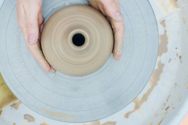 Çömlekçi çarkında çalışan kadınlar. Eller bardaktan bir kupa yontuyor.