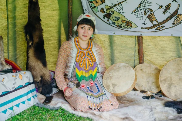 Vacker ung kvinna med en schamansk trumma i en wigwam spelar etnisk musik — Stockfoto