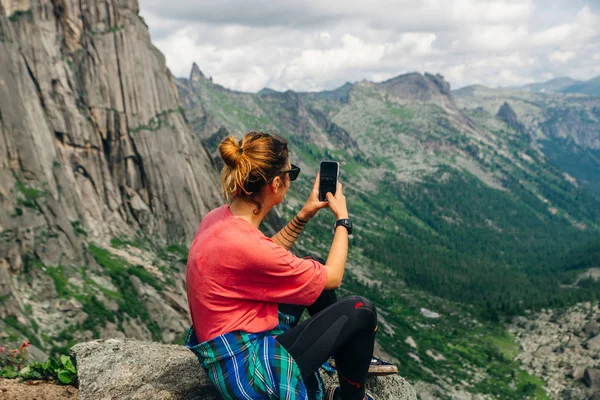 Femme assise sur une montagne avec un beau fond de nature — Photo