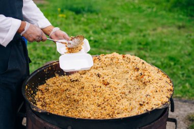 Dev bir kazanda gerçek Özbek pilavı. Ulusal yemekleri pişirmek.