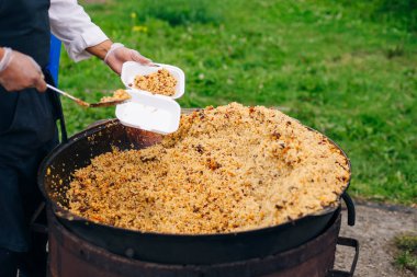 Dev bir kazanda gerçek Özbek pilavı. Ulusal yemekleri pişirmek.