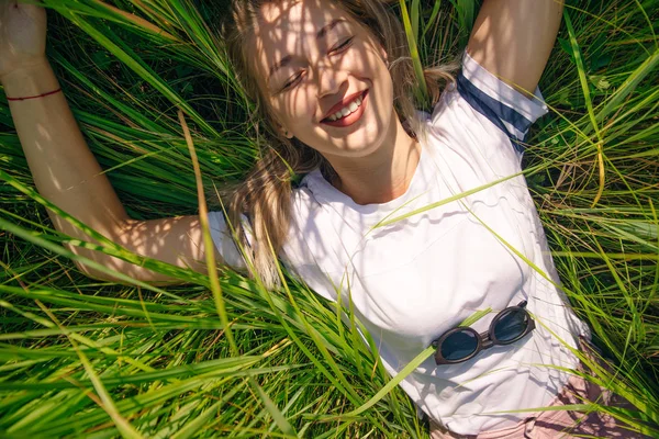 T-shirt design concept - mooi meisje ligt in gras in wit t-shirt — Stockfoto