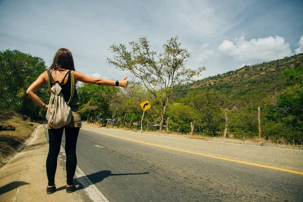 Cute American woman hitchhiking in latin america — ストック写真