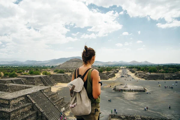 Teotihuacan, Meksika. Sırt çantası ve şapkalı Meksikalı Amerikalı bir turist, Piramidin tepesinden manzaranın keyfini çıkarır. Güneş