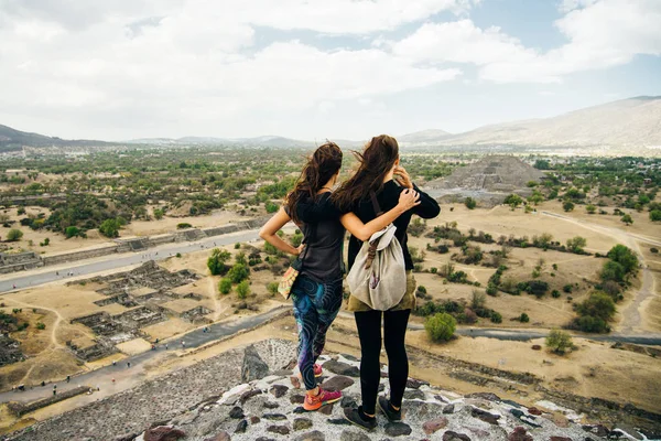 Grupo de amigos sentados juntos em uma montanha e olhando para pirimidas — Fotografia de Stock