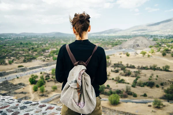 Teotihuacan, Meksika. Sırt çantası ve şapkalı Meksikalı Amerikalı bir turist, Piramidin tepesinden manzaranın keyfini çıkarır. Güneş