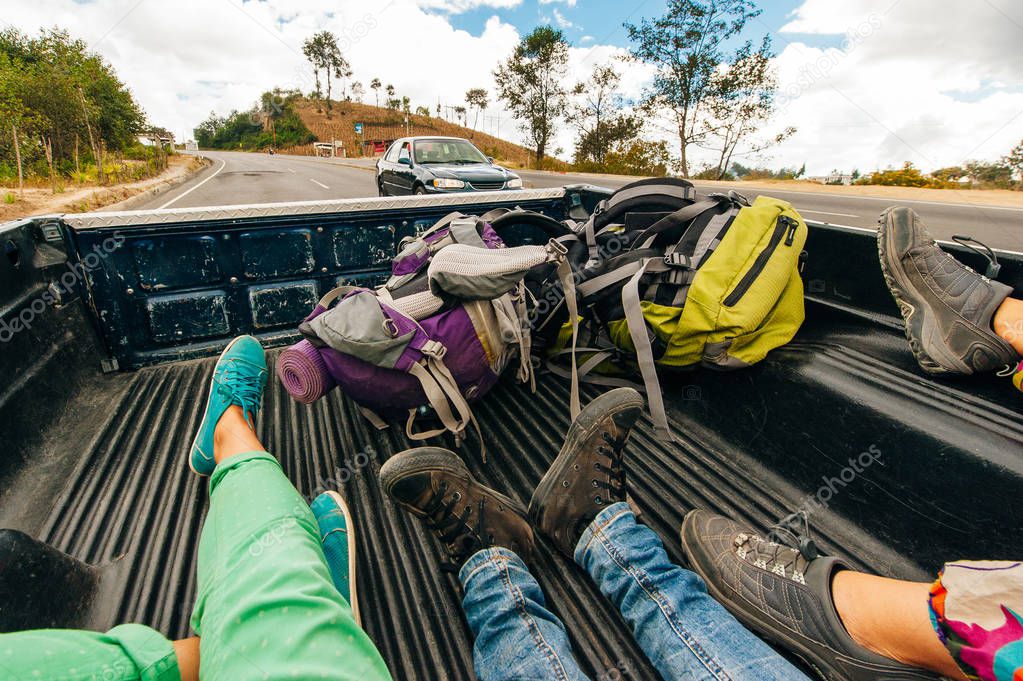 Legs of two hitchhiker man and woman traveling in pickup car