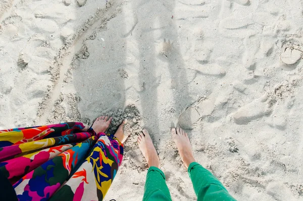 Woman feet on sand. Seashore sand beach texture. Ocean coast top view photo.