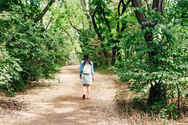 Młoda dziewczyna spacerująca po piaszczystej ścieżce w parku miejskim — Zdjęcie stockowe
