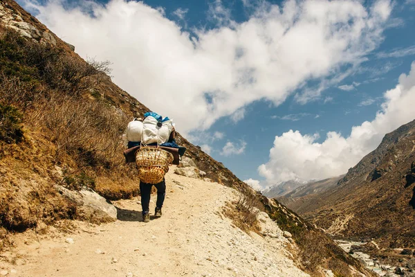 Porter e Sherpa camminano con bagaglio a mano in Himalaya Mountains in Nepal . — Foto Stock