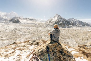 kayanın üzerinde oturan ve Vadi Manzaralı zevk genç kadın