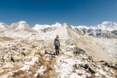 Kızla manzara, karlı tepeli yüksek dağlar, yol, Nepal 'de mavi gökyüzü. Seyahat et. Eski tarz. Doğa