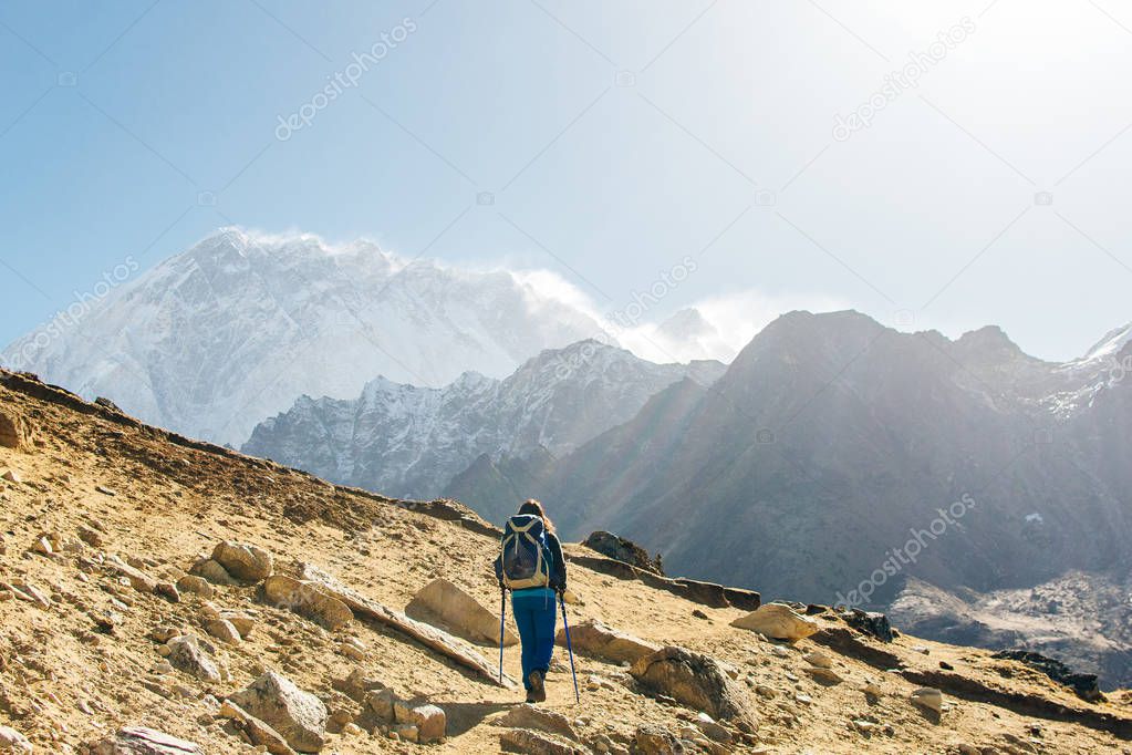 Landscape with girl, high mountains with snowy peaks, path, blue sky in Nepal. Travel. Vintage style. Nature