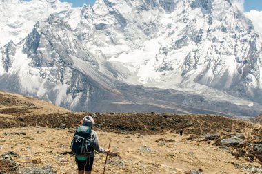 Kızla manzara, karlı tepeli yüksek dağlar, yol, Nepal 'de mavi gökyüzü. Seyahat et. Eski tarz. Doğa