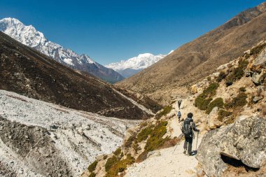 Kızla manzara, karlı tepeli yüksek dağlar, yol, Nepal 'de mavi gökyüzü. Seyahat et. Eski tarz. Doğa