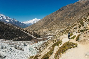 Kızla manzara, karlı tepeli yüksek dağlar, yol, Nepal 'de mavi gökyüzü. Seyahat et. Eski tarz. Doğa