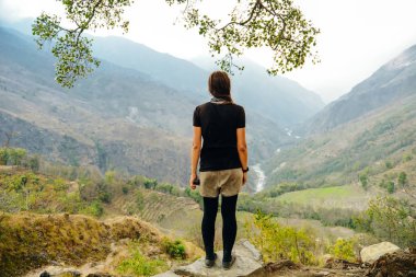 Sırt çantalı hippi genç kız Hüznün zirvesinde günbatımının tadını çıkarıyor