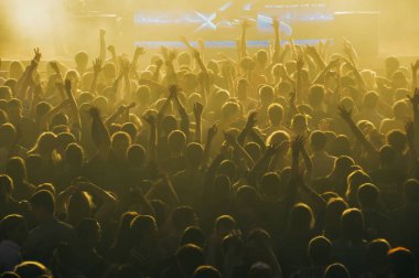 Karanlıktaki stadyum konserinde büyük bir kalabalık.
