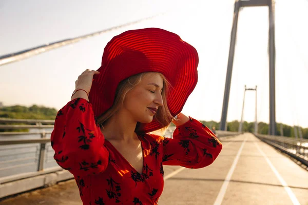 Vacker ung flicka i en röd klänning och röd hatt — Stockfoto