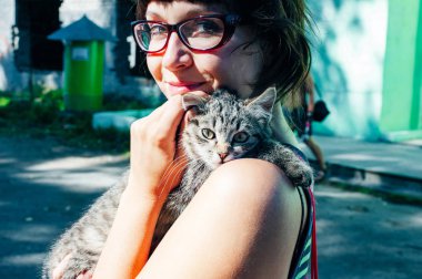 Tatlı ve sevimli kedisine sarılan bir kadın Kitty insanların kollarında mırlıyor..