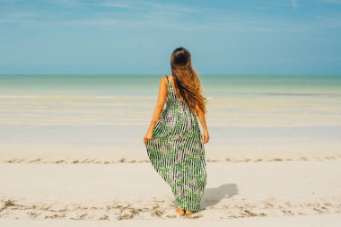 Güzel bir kız sırtı Meksika sahilinde duruyor..