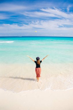 Okyanusun arka planında şapkalı bir kız. Güzel kız denize bakıyor.