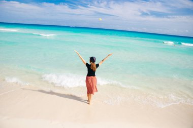 Okyanusun arka planında şapkalı bir kız. Güzel kız denize bakıyor.
