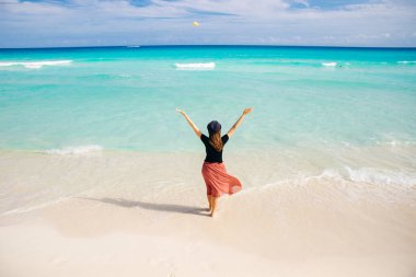 Okyanusun arka planında şapkalı bir kız. Güzel kız denize bakıyor.