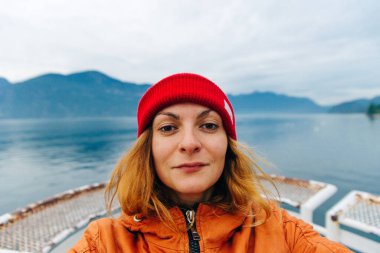 Gezgin gölün arka planında özçekim yapıyor. Vancouver, Kanada.