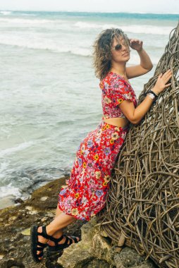 Okyanusun arka planında parlak elbiseli sarışın..