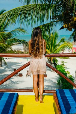 Güzel bir kız sırtı Meksika sahilinde duruyor..