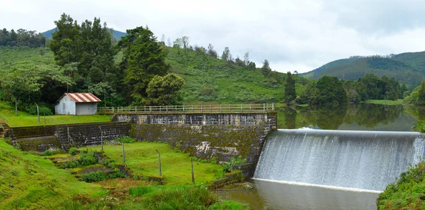 Nilgiris 'teki tarihi bir kontrol barajının manzaralı fotoğrafı yağmur mevsiminde taşan suyu gösteriyor. Çek barajı, su akışını azaltmak için kırlangıç, drenaj ya da su yolu üzerine inşa edilen küçük, bazen geçici bir barajdır.