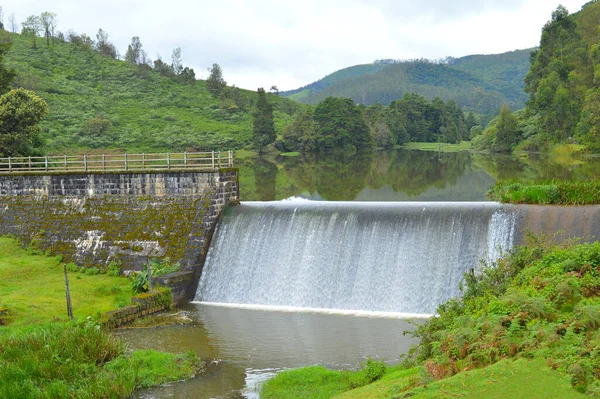 Nilgiris 'teki tarihi bir kontrol barajının manzaralı fotoğrafı yağmur mevsiminde taşan suyu gösteriyor. Çek barajı, su akışını azaltmak için kırlangıç, drenaj ya da su yolu üzerine inşa edilen küçük, bazen geçici bir barajdır.