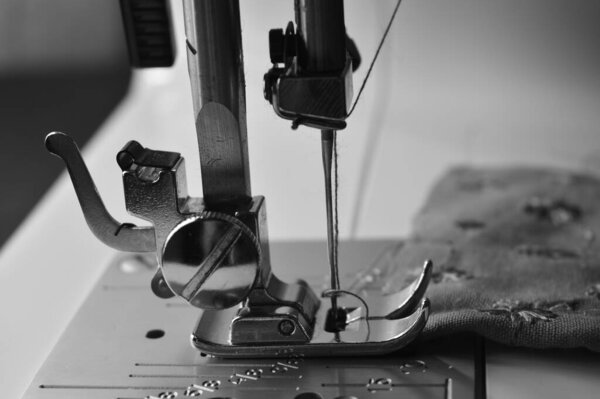 image of a sewing machine showing thread and needle. A sewing machine is a machine used to sew fabric and materials together with thread. Sewing machines were invented during the first Industrial Revolution to decrease the amount of manual sewing wor