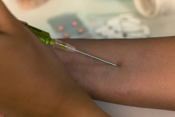 Close up. Female addict injects chemical dose in vein on right arm. Methamphetamine concept.