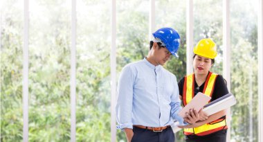 Mühendisler bir tabletle toplantı odasında çalışıyorlar. İki işçi inşaat planını izliyor. Ofiste. Elektrikçiler, marangozlar, teknik operatörler ve İşçiler veya Taşımacılar..