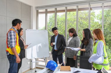 Mühendisler tahtada toplanıyor. Planlı İç Tasarım Yapısı ve Geliştirmesi. Takım ve müvekkil için müteahhit sunumu. Asyalılar.
