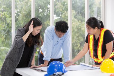 Ofiste üç mühendis toplantı odasında çalışıyor. Üç işçi inşaat planından bahsediyor. Elektrikçiler, marangozlar, teknik operatörler ve İşçiler veya Taşımacılar.