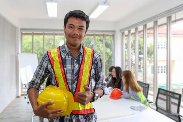 Portrait of Asian male contractor engineer in meeting room. at the office. Electricians carpenter or technical operaters and labourers or moving operators. The engineer holds the thumb that translates as excellent.