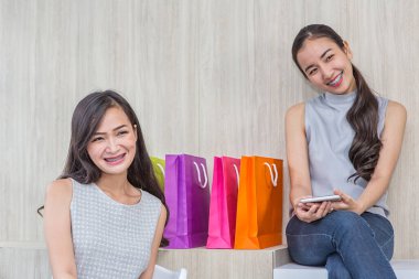 Kafede kredi kartı ve akıllı telefonla ödeme yapan mutlu bir kadın. Kadın temassız ödeme almış. İnsanlar, finans, teknoloji ve tüketici konsepti. Çevrimiçi alışverişte cep telefonuyla ödeme yapan gülümseyen genç bir kızın fotoğrafı..