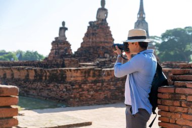 Doğu Asya yaz tatili. Kafkasyalı turist Wat Chaiwatthanaram tapınağına bakıyor. Gezginler DSLR kameralarıyla fotoğraf çeker. Tayland 'ın Ayutthaya şehrinde seyahat et. Asya turisti.