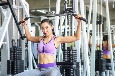 Spor salonunda bir kadın. Spor, spor, vücut geliştirme, spor salonunda egzersiz yapan ve kaslarını esneten kadınlar. Asyalı kız.