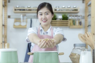 Yeni bir aşçının ellerinde soya fasulyesi. Güzel Asyalı kadın yeni mutfağını gösteriyor. Soya sütlü tofu yapıyorum. Seçici odak.