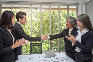 El sıkışalım. İş ortağı ofiste el sıkışıyor. Ofiste tokalaşan iki işadamı. Asyalı. Ofiste. Bilgisayarla sunum. Asyalılar.