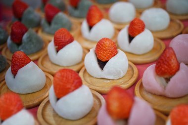 Strawberry mochi rice cake. Close Up of Dessert Fruit and rice cake on wood disk at Japan. Japan mochi. Kyoto street food. clipart