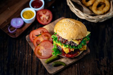 Taze ve sulu hamburger. Biftek ya da pastırmalı çizburger, domates, soğan halkası ve domates sosu ya da ketçap..