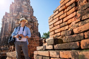 Doğu Asya yaz tatili. Kafkasyalı turist Wat Chaiwatthanaram tapınağına bakıyor. Gezginler DSLR kameralarıyla fotoğraf çeker. Tayland 'ın Ayutthaya şehrinde seyahat et. Asya turisti.