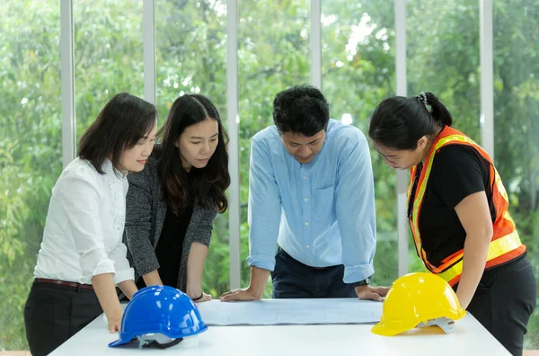 기술자들이 작업하고 사무실에서 계획과 헬멧을 회의를 — 스톡 사진
