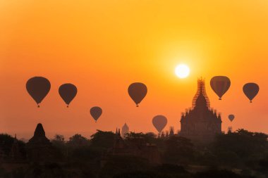 Bagan, Myanmar 'da bir sürü sıcak hava balonu doğuyor. Bagan tarihi Budist tapınakları ve aptalları olan eski bir tapınaktır. Pagoda depremden sonra tamir ediliyor. Metin için boşluk.