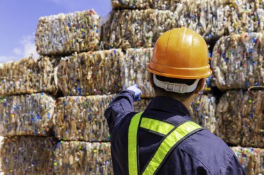 Foreman ya da mühendis koruyucu giysiler giyiyor. Şu anda plastik geri dönüşüm tesisinden sipariş veriyor. Mühendis ve geri dönüşüm. Geri dönüşüm merkezinde duran mühendisler.